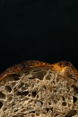 Sourdough sliced bread with big pores close up on a black background