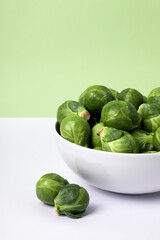 Brussels sprouts on a plate on a white and green backgrounds