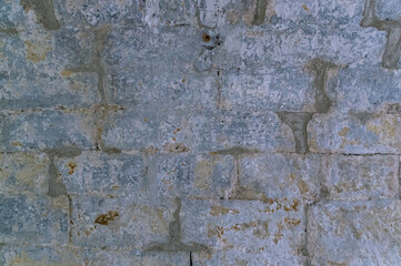 The base of the ancient building is made of light sandstone. The background is made of processed blocks of light gray sandstone.