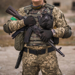 Soldier of the Armed Forces of Ukraine. Military man in tactical uniform with a machine gun in his...