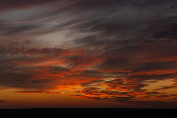 Fototapeta na wymiar A beautiful orange sunset with clouds over the horizon