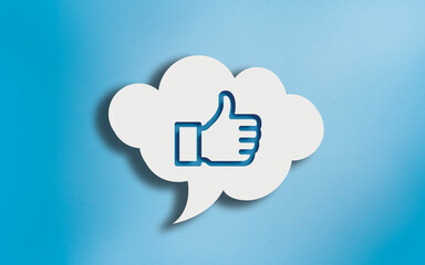 Thumbs Up Icon in White Cloud Speech Bubble on Blue