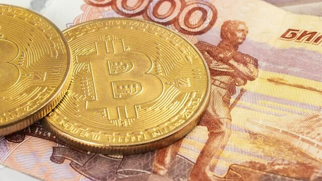 Bitcoin coins (new virtual money) on Russian banknotes A close up image of bitcoins with Russian rubles banknotes Bitcoin coin on the background of Russian rubles Bitcoin Russia Ruble Cryptocurrency