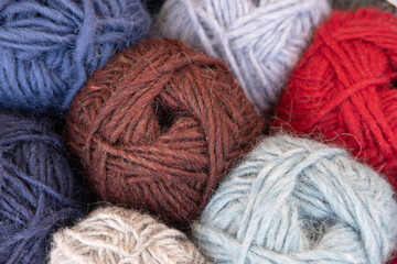 Woolen yarn balls, skeins of tangled colorful sewing thread. Selective focus
