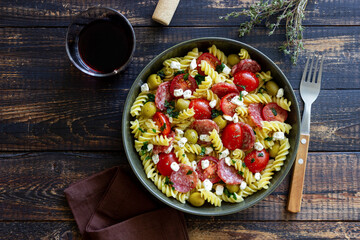 Salad with fusilli pasta, sausage, olives and cottage cheese. Italian food.