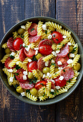 Salad with fusilli pasta, sausage, olives and cottage cheese. Italian food.