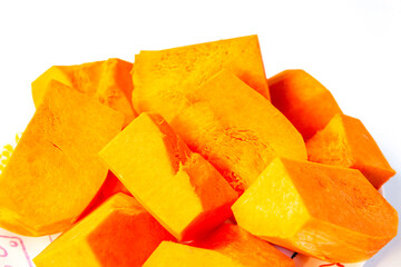 Sliced pieces of pumpkin on a plate on a white background.