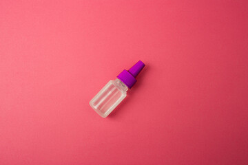 A small cosmetic bottle on a pink background