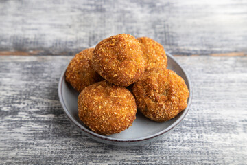 meat balls on a wooden plate on a gray. Side view.