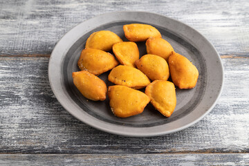 fried dumplings on a wooden plate on a gray. Side view.