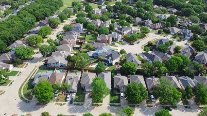 Top view an established neighborhood with matured trees and two story houses in Flower Mound, Texas, US