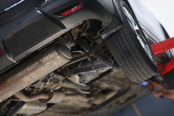Car lifted in maintenance service for checkup, undercarriage of automobile, bottom view