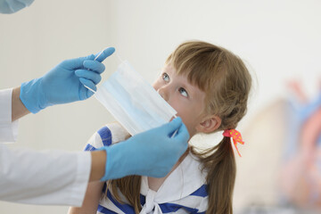 Doctor put face mask on kid face to protect from virus spread