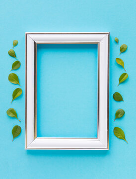 Beautiful flower arrangement. Small green leaves, empty photo frame for text on a blue background. Wedding. birthday. Valentine's Day. mothers Day. top view, copy space