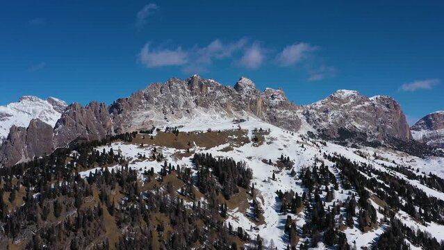 Pizes de Cir Mountain Range and Gardena Pass on Sunny Winter Day. South Tyrol, Dolomites, Italy. Aerial View . Drone Flies Sideways