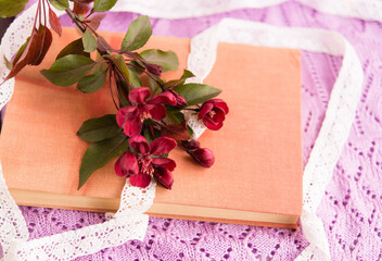 old book with red small flowers on a lilac openwork background close-up