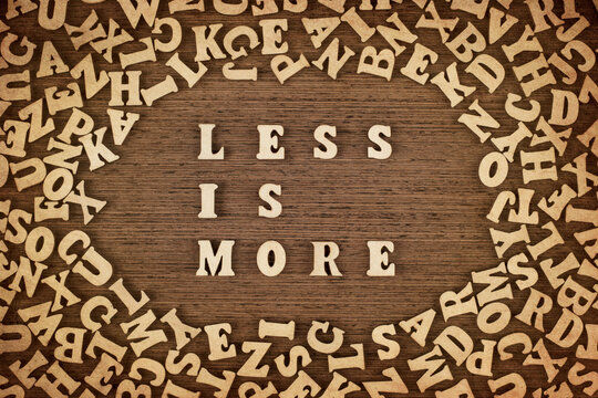 "Less is more" phrase made with wooden letters on table, concept.