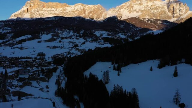 Sas dla Crusc Mountain. Dolomite Alps in Winter at Sunset. Badia, South Tyrol, Italy. Aerial View. Drone Flies Forward, Tilt Up. Reveal Shot