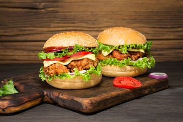 Close-up of delicious homemade burgers on wooden table. Delicious freshly prepared chicken, pork, or beef hamburgers.