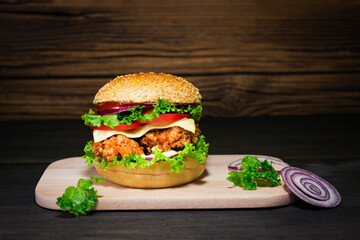 Close-up of delicious homemade burgers on wooden table. Delicious freshly prepared chicken, pork, or beef hamburgers.