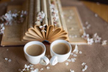 Cups of coffee on wooden background with fresh flowers in bloom. Art decoration. Breakfast concept