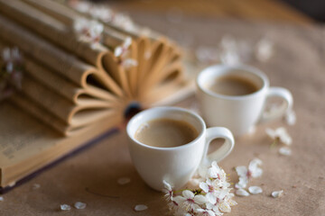 Cups of coffee on wooden background with fresh flowers in bloom. Art decoration. Breakfast concept