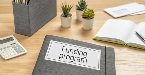 A folder on a desk with the label Funding program