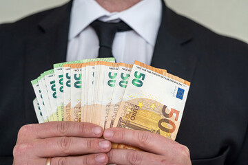 Business man in suit holding euro and dollar banknote for exchange rate.