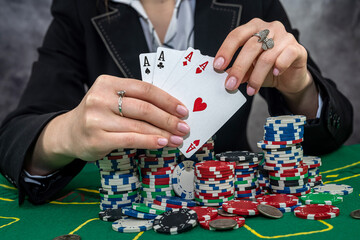 Woman in suit playing poker with cards and chips