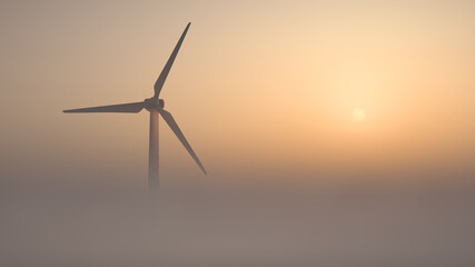 Wind generator on a foggy morning against the backdrop of the rising sun. Green energy theme