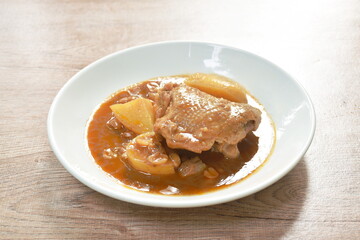 chicken thigh massaman curry with slice potato and peanut on plate