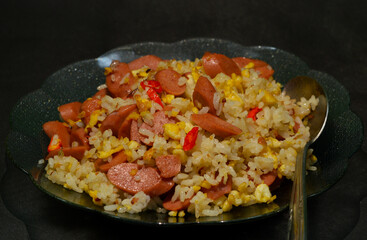 Fried rice with sausage and egg garnished with chili slices