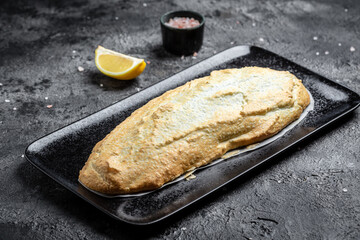 Fish covered in meringue salt. Tray with fish and lemon. Breaded river trout fish. New recipe of delicious fish. still life. top view. Healthy food