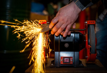 The process of sharpening scissors on metal with the release of a large number of bright sparks