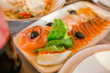 Dish. Sliced red fish, lettuce, lemon, olives, microgreens