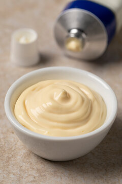 Bowl with Mayonnaise and a tube of mayonnaise in the background