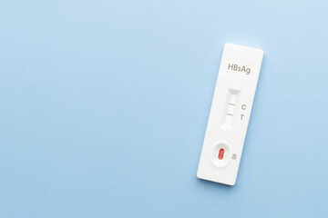 Hepatitis B Virus Surface Antigen Test Kit with positive result on blue background. Screening for hepatitis B uses a blood sample, collected from a finger prick. World hepatitis day.