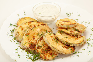 Fried zucchini with sauce in white plate.
