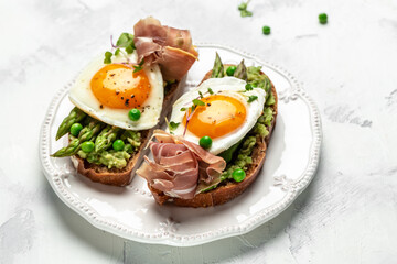 Grilled Toast witch Asparagus, fried egg, bacon jamon, ham, prosciutto on white background. Long banner format. top view