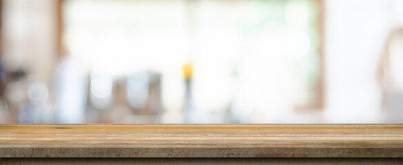 Wooden table top with blurred people in coffee shop and cafe background for display montage, copy space.