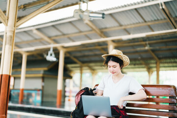 summer, relax, vacation, travel, portrait of beautiful Asian girl using the computer laptop at the train station while waiting for their travel time.