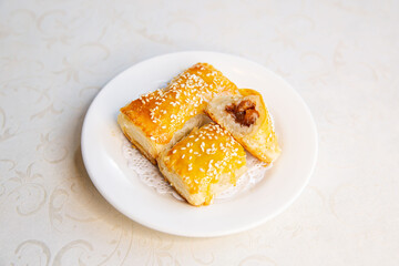 Char Siew barbecued pork puff cake dim sum of traditional Cantonese yum-cha Asian gourmet cuisine meal food dish on the white serving plate and white table
