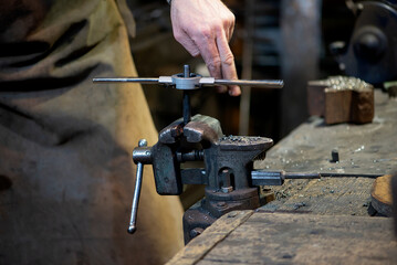 Professional blacksmith working with metal  at forge, workshop. Handmade, craftsmanship and blacksmithing concept