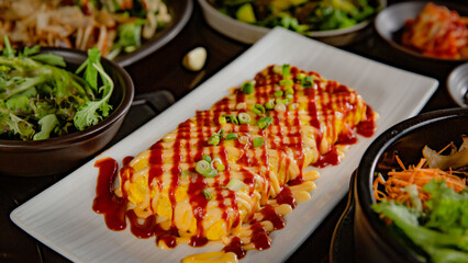 Korean Grilled BBQ combo sets with an omelette on the traditional grill table, and pickle dishes