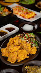 Korean Grilled BBQ combo sets with fried chicken, beef tartare on the traditional grill table, and pickle dishes