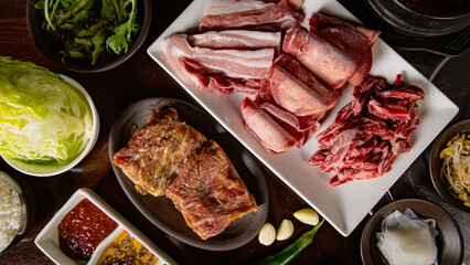 Top view of Korean Grilled BBQ combo with pork belly, wagyu, marinated beef set on the traditional...