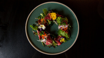 Top view of Tartare beef flower circle salad in the fine dining Japanese restaurant, with a green...