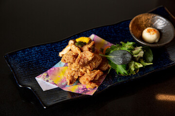 Fried king oyster mushroom in the fine dining Japanese restaurant, with mayonnaise and salad in a fine plating in black scene reflection table background