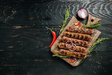 Lula kebab, traditional Caucasian dish. On the black background of the concrete, on a chopping...