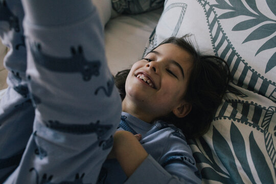 Happy playful girl lying on bed at home